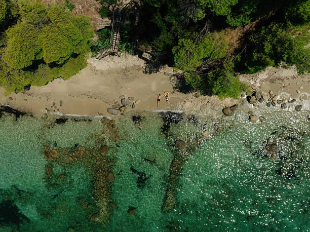 Aerial photo of a mid adult couple sunbathing together at the sandy beach