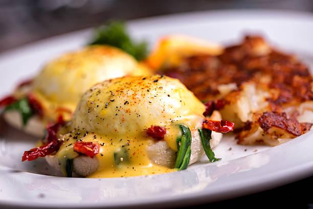Fancy eggs benedict with sun dried tomatoes and spinach, coffee and orange juiceFancy eggs benedict with sun dried tomatoes and spinach, coffee and orange juice