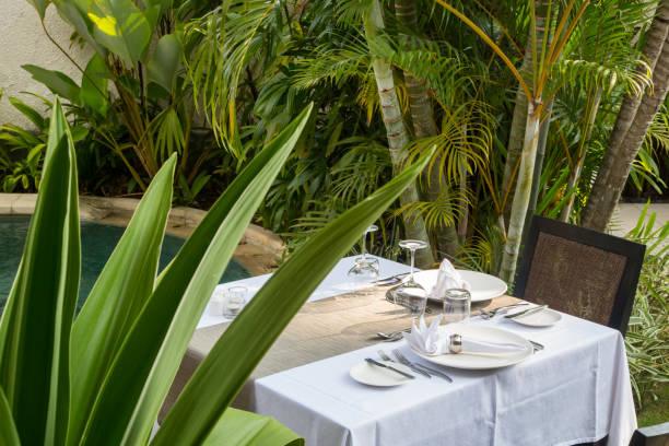 Outdoor white table set up for lunch with empty plates