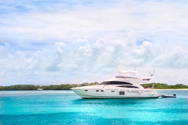 Luxury yachts anchored in a Tropical island turquoise beach. Francisqui cay. Boats, sailboats and yachts anchored in a Caribbean island. Travel and leisure related images for vacations in the Caribbean. Image taken at Los Roques, Venezuela. Los Roques is an archipelago or group of small islands located at 80 miles north of the Venezuelan coastline and a very popular destination for leisure, diving, kite surfing and all king of water activities. Los Roques and the beauty of the turquoise coastal beaches of Venezuela are almost indistinguishable from those of the Bahamas, Fiji, Bora Bora, French Polynesia, Malau, Hawaii, Cancun, Costa Rica, Florida, Maldives, Cuba, Puerto Rico, Honduras, or other tropical areas.